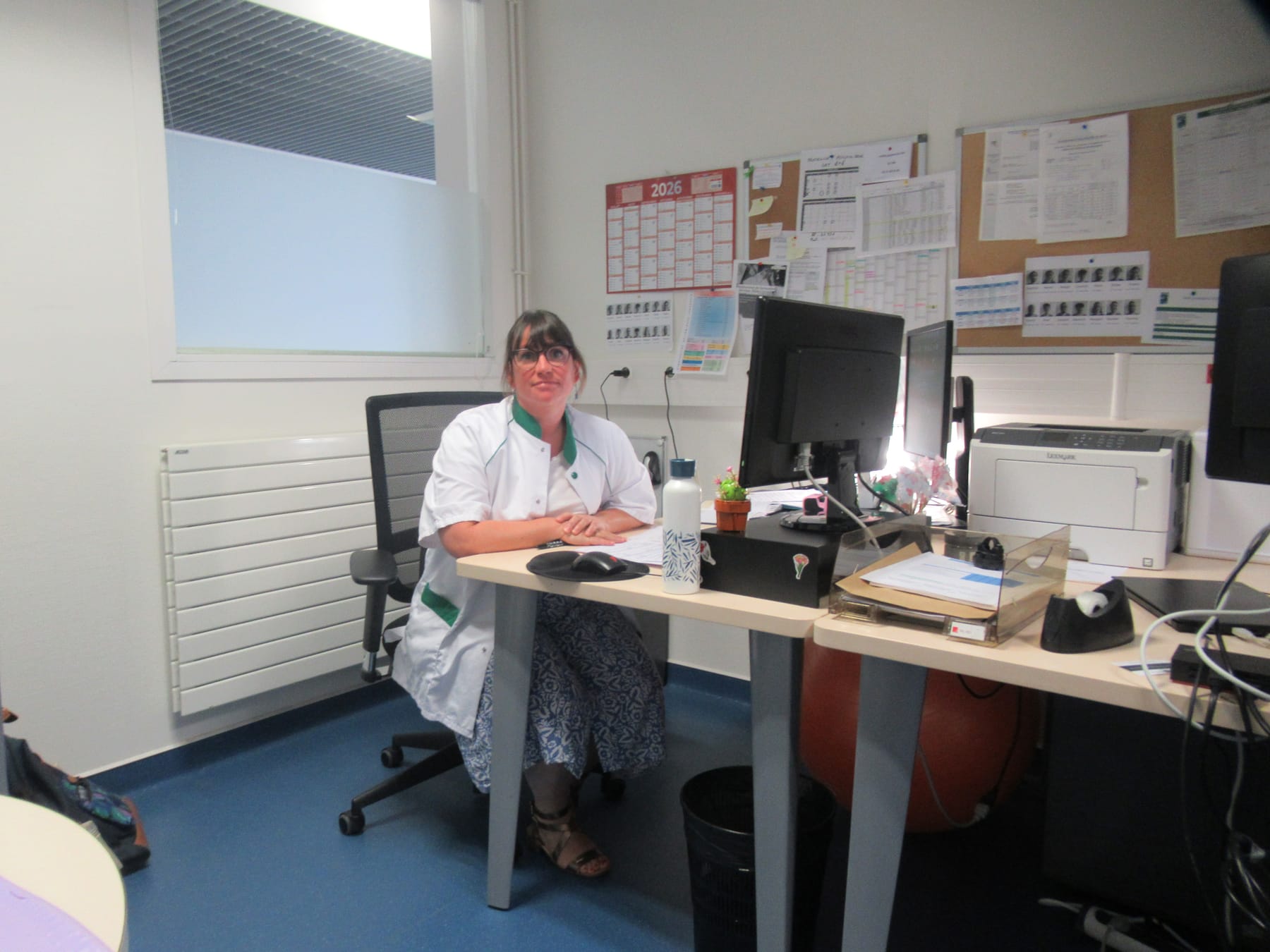 Une cadre de santé du service à son bureau, devant les plannings de l'équipe.